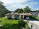 This single-story home includes a covered carport and a well-manicured front lawn with mature landscaping at 7 Lamplight Ln, Winter Haven, FL 33884