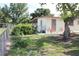 The exterior showcases a quaint backyard patio accessible through a gate and shaded by mature trees at 7 Lamplight Ln, Winter Haven, FL 33884