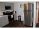 Updated kitchen featuring stainless steel refrigerator, gray cabinets, and modern backsplash at 7 Lamplight Ln, Winter Haven, FL 33884