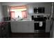 Modern kitchen featuring gray cabinets, stainless steel appliances, and a cozy dining area at 7 Lamplight Ln, Winter Haven, FL 33884