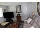 Comfortable living room with leather sofa, TV, round decorative mirror, side table and lamp at 7 Lamplight Ln, Winter Haven, FL 33884