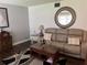 Cozy living room with leather sofa, decorative mirror, accent table and rug at 7 Lamplight Ln, Winter Haven, FL 33884
