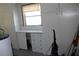 Storage room with white cabinets, window, and cleaning supplies at 7 Lamplight Ln, Winter Haven, FL 33884