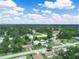 Expansive aerial view of a lush community with mature trees under a bright, partly cloudy sky at 715 S Seminole Ave, Fort Meade, FL 33841
