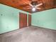 This bedroom has a ceiling fan and two closets on green walls at 715 S Seminole Ave, Fort Meade, FL 33841