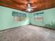 This room features a ceiling fan and two windows with green walls at 715 S Seminole Ave, Fort Meade, FL 33841