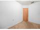 A bright empty bedroom with beige carpet, white walls and trim and a wooden door at 715 S Seminole Ave, Fort Meade, FL 33841