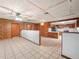 Open-concept kitchen with white tile floors, and wood paneled walls at 715 S Seminole Ave, Fort Meade, FL 33841