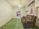 This charming living room has green carpet with a view into the kitchen at 715 S Seminole Ave, Fort Meade, FL 33841