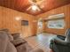 Cozy living room features wood paneling, ceiling fan and comfortable seating at 715 S Seminole Ave, Fort Meade, FL 33841