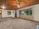 Living room with a decorative wood ceiling, carpeted floor and a large window with blinds at 715 S Seminole Ave, Fort Meade, FL 33841