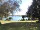 Spacious backyard with a lake view framed by mature trees, providing a serene and private setting at 7254 Wisteria Ln, Lake Wales, FL 33898