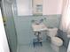 Charming bathroom with blue tiles, a pedestal sink, a toilet, and a glass-enclosed shower at 7254 Wisteria Ln, Lake Wales, FL 33898