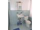 Compact bathroom featuring blue tile, a classic sink, a toilet, and shower with glass doors at 7254 Wisteria Ln, Lake Wales, FL 33898