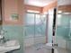 Compact bathroom featuring unique ceramic tile, glass shower door, and charming vintage fixtures at 7254 Wisteria Ln, Lake Wales, FL 33898