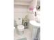 Compact bathroom features a pedestal sink, toilet, and white tiled walls at 7254 Wisteria Ln, Lake Wales, FL 33898