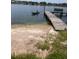 Lakeside dock with bench seating and a person kayaking on the water at 7254 Wisteria Ln, Lake Wales, FL 33898