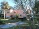 View of a two-story home with mature trees, a long driveway, and well-kept landscaping at 7254 Wisteria Ln, Lake Wales, FL 33898