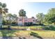 Charming two-story home with a manicured lawn, mature palm trees, and a black metal fence at 7254 Wisteria Ln, Lake Wales, FL 33898