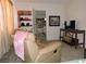 Cozy living room with a recliner, TV, and doorway to another room with built-in bookshelves at 7254 Wisteria Ln, Lake Wales, FL 33898