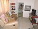 Inviting living room featuring a plush recliner, decorative shelves, and a glimpse into the adjacent bedroom at 7254 Wisteria Ln, Lake Wales, FL 33898
