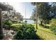 Well-manicured yard with lush greenery and a glimpse of the lake, offering a peaceful outdoor retreat at 7254 Wisteria Ln, Lake Wales, FL 33898