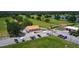 Aerial view of a community building, golf course, and lush green surroundings at 7591 Limonia Dr, Indian Lake Estates, FL 33855