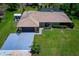 Aerial view of the property showcases the front yard, long driveway and mature landscaping at 7591 Limonia Dr, Indian Lake Estates, FL 33855