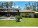 View of the screened-in pool area and lush green yard at 7591 Limonia Dr, Indian Lake Estates, FL 33855
