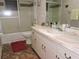 Functional bathroom with tub/shower, a large mirror, and updated vanity with storage space at 7591 Limonia Dr, Indian Lake Estates, FL 33855