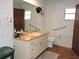 Bathroom featuring vanity with integrated sink, toilet, hand rails and storage space at 7591 Limonia Dr, Indian Lake Estates, FL 33855