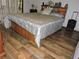Comfortable bedroom with stylish wooden floors, storage bed, and decor at 7591 Limonia Dr, Indian Lake Estates, FL 33855