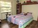 Bright bedroom featuring natural light, built-in shelves, and durable wood-look floors at 7591 Limonia Dr, Indian Lake Estates, FL 33855