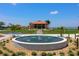 Community fountain and building with a lake backdrop and an outdoor seating area at 7591 Limonia Dr, Indian Lake Estates, FL 33855