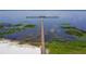 Aerial view of long dock over lake, a serene location for sunset views and enjoying the peaceful water at 7591 Limonia Dr, Indian Lake Estates, FL 33855