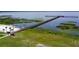 Aerial view of community dock extending into the lake, perfect for fishing and enjoying waterfront views at 7591 Limonia Dr, Indian Lake Estates, FL 33855