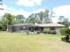 The exterior shows a screened pool and patio with a well-maintained lawn and landscaping at 7591 Limonia Dr, Indian Lake Estates, FL 33855