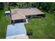 Charming single-story home with lush lawn, covered porch, and convenient attached garage at 7591 Limonia Dr, Indian Lake Estates, FL 33855