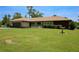 Well-maintained home with a tile roof, verdant lawn, and attractive landscaping at 7591 Limonia Dr, Indian Lake Estates, FL 33855