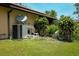Home exterior features a well maintained lawn, air conditioning unit and manicured bushes at 7591 Limonia Dr, Indian Lake Estates, FL 33855