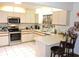 Inviting kitchen featuring a window above the sink, white appliances and tiled flooring at 7591 Limonia Dr, Indian Lake Estates, FL 33855