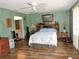 Bright main bedroom featuring wood floors, ceiling fan and light green colored walls at 7591 Limonia Dr, Indian Lake Estates, FL 33855