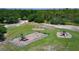 Aerial view of a community playground with play structures and swings in a leafy, green area at 7591 Limonia Dr, Indian Lake Estates, FL 33855