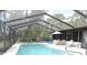 A screened-in pool with a patio and landscaped yard is perfect for outdoor living at 7591 Limonia Dr, Indian Lake Estates, FL 33855