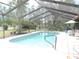 A screened-in pool with a patio and landscaped yard is perfect for outdoor living at 7591 Limonia Dr, Indian Lake Estates, FL 33855