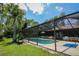 Pool area is screened in with a spacious patio and beautiful landscaping at 7591 Limonia Dr, Indian Lake Estates, FL 33855