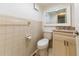 Cozy half-bathroom with tiled walls, a single vanity sink, and a toilet at 821 Orchid Springs Dr # 821, Winter Haven, FL 33884