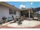 A view of the back patio showing an outdoor seating area adjacent to the partially screened-in back porch at 882 Redwood Way, Lake Wales, FL 33898
