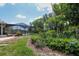 A backyard view, showing the garden and screened-in pool area adding to the tranquility of the outdoor space at 882 Redwood Way, Lake Wales, FL 33898