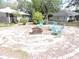 Backyard with a fire pit surrounded by chairs for outdoor gathering, nestled among mature trees at 882 Redwood Way, Lake Wales, FL 33898